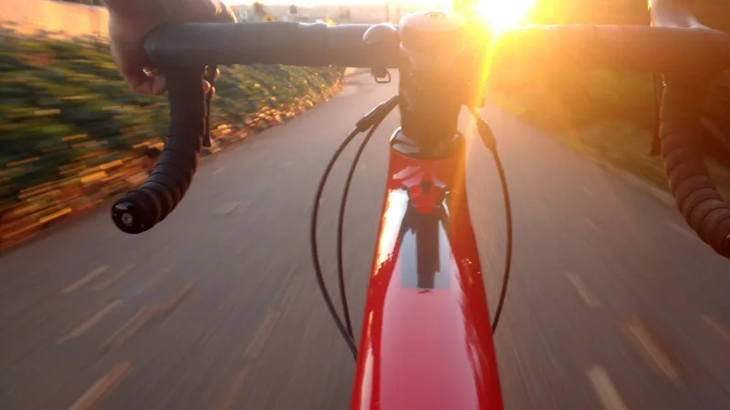 Riding a red road bike into the sunset